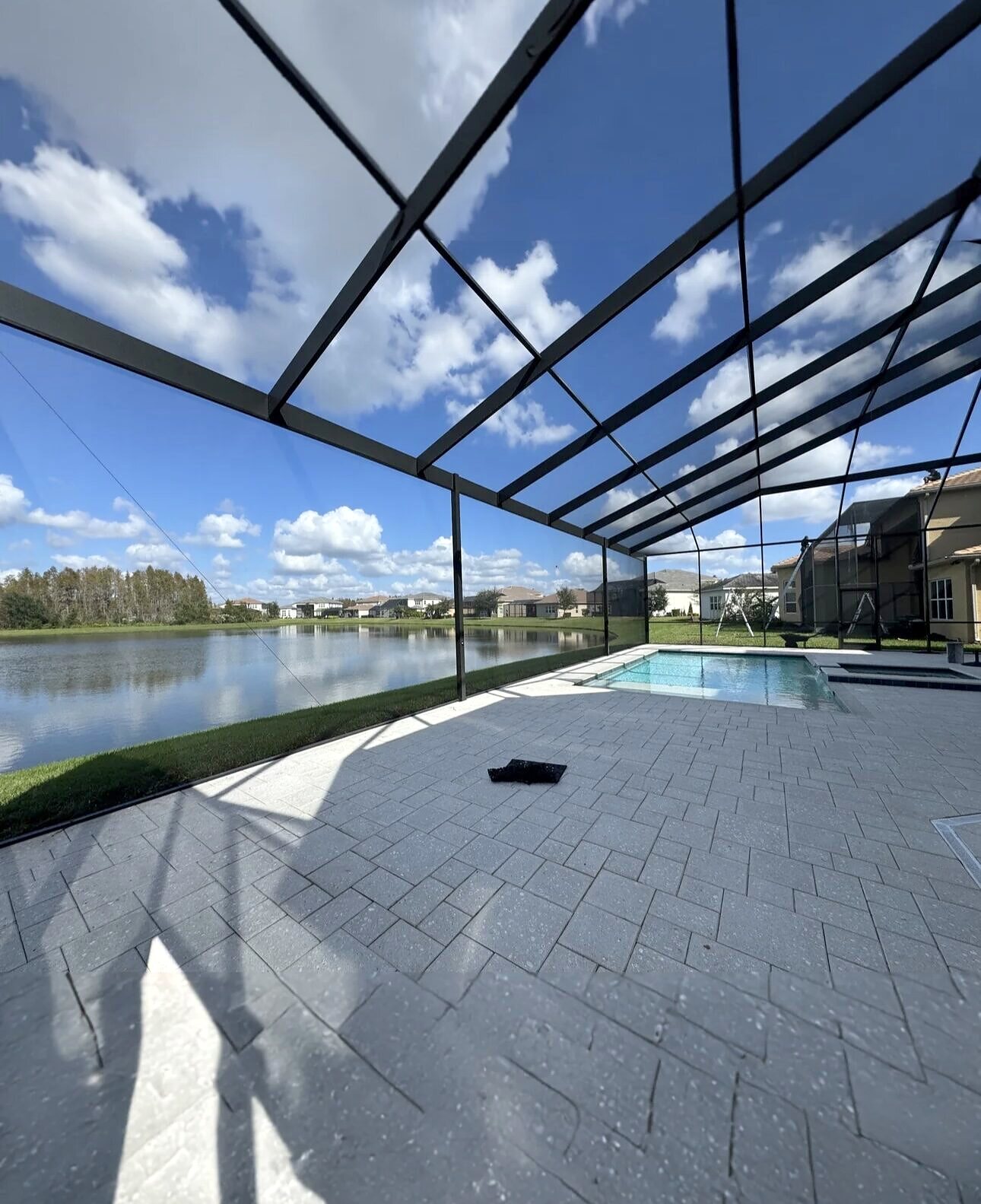 Completed pool cage screen enclosure with a lakefront view